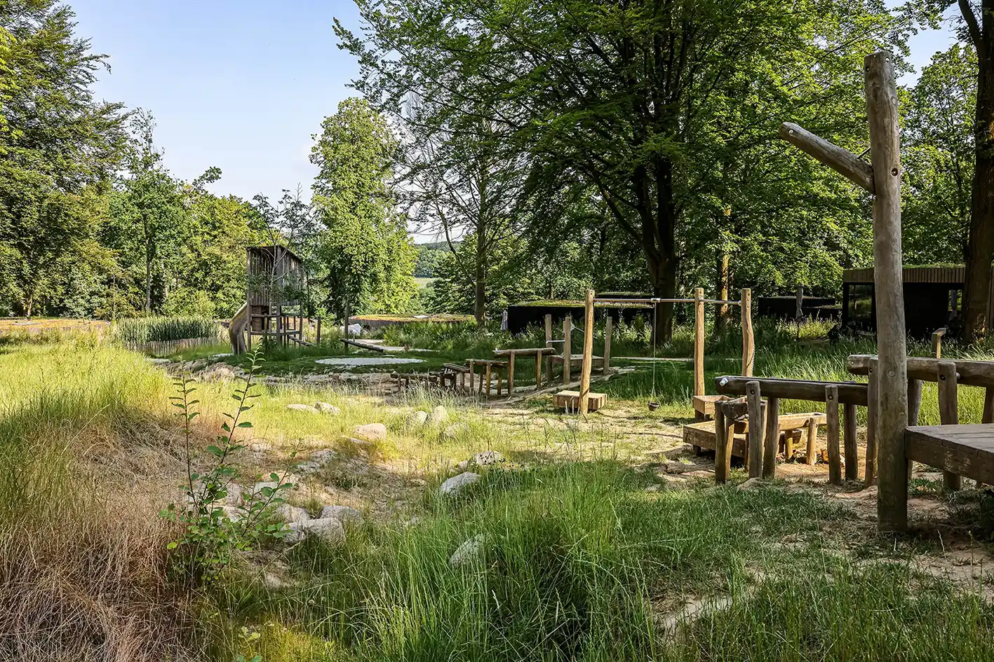 http://Natuurlijke%20speelplek%20van%20hout%20met%20avontuurlijke%20paden%20in%20het%20groen%20van%20een%20vakantiepark