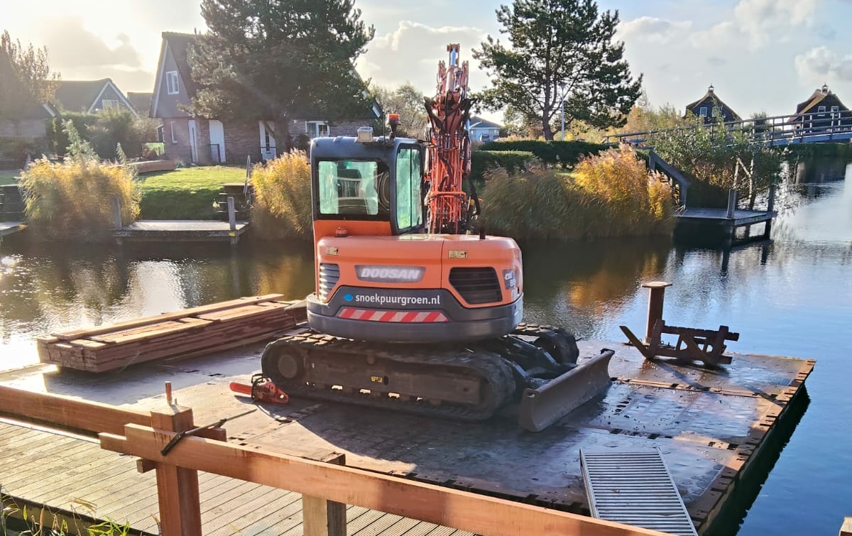 Kraaan die werkzaamheden uitvoert op het water aan een vlonder